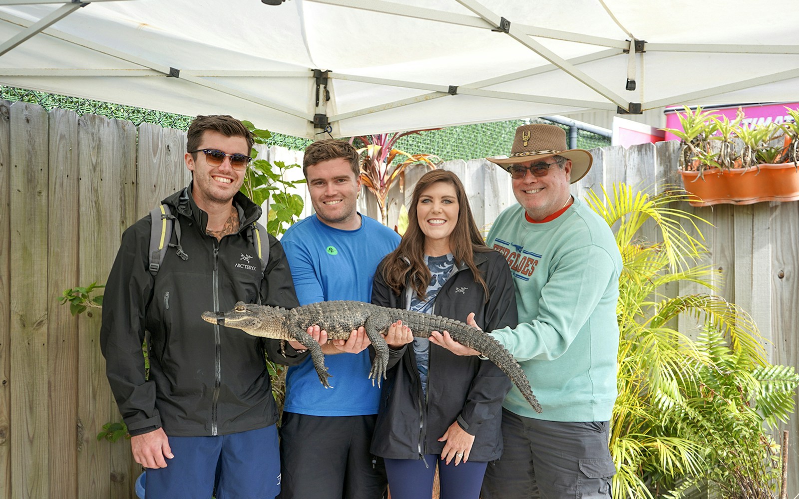 Guests holding a small alligator at Everglades Holiday Park animal encounter.