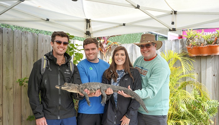 Guests holding a small alligator at Everglades Holiday Park animal encounter.
