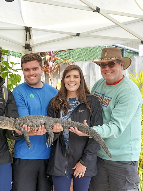 Guests holding a small alligator at Everglades Holiday Park animal encounter.