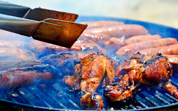 Grilled chicken and sausages on barbecue at Ile Aux Cerf.