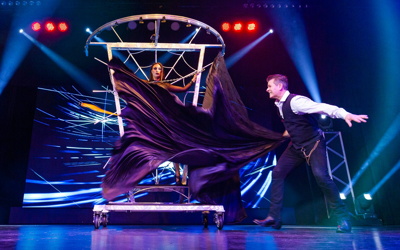 Magician performing an illusion with an assistant at The Wild Magic Show, Greg Frewin Theatre.