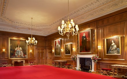 Historic room with portraits and chandelier at Palace of Holyroodhouse, London.