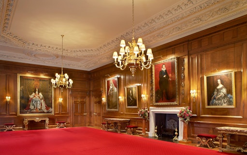 Historic room with portraits and chandelier at Palace of Holyroodhouse, London.
