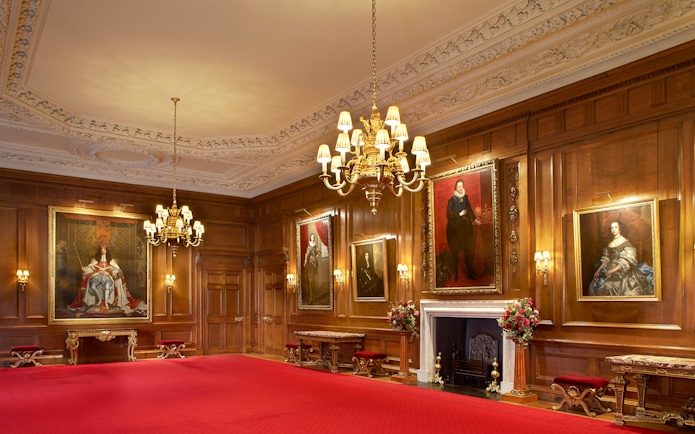 Historic room with portraits and chandelier at Palace of Holyroodhouse, London.