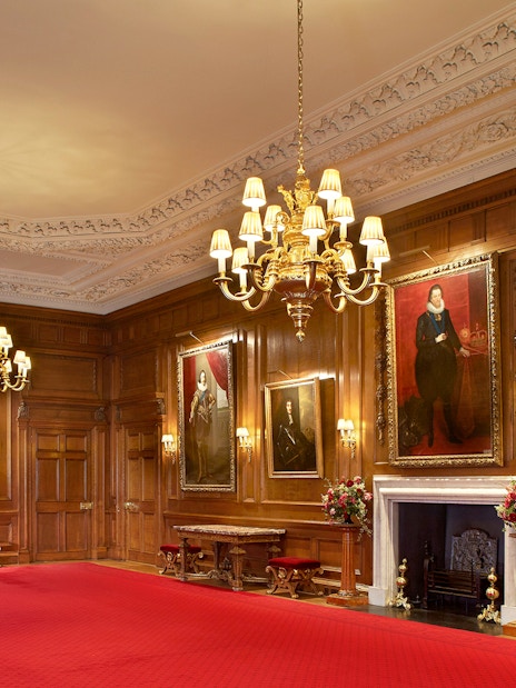 Historic room with portraits and chandelier at Palace of Holyroodhouse, London.