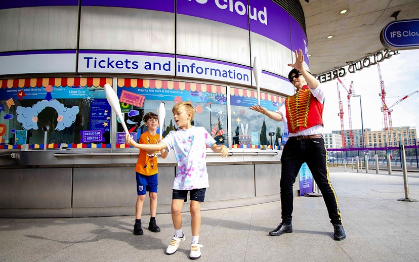 Guests juggling at IFS Cloud Cable Car ticket area in London.