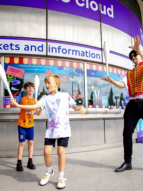 Guests juggling at IFS Cloud Cable Car ticket area in London.
