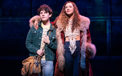 Two actors on stage in a scene from the musical "Almost Famous.