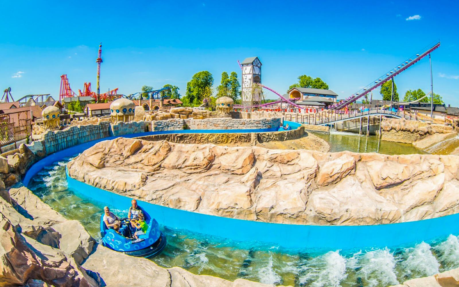 Atlantis river ride at Energylandia with people on a water raft descending a steep drop.