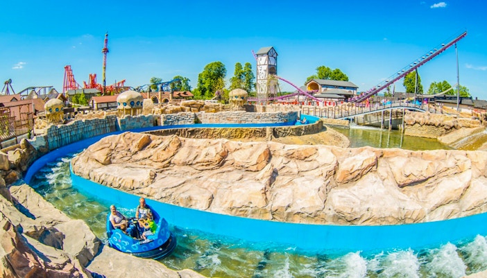 Atlantis river ride at Energylandia with people on a water raft descending a steep drop.