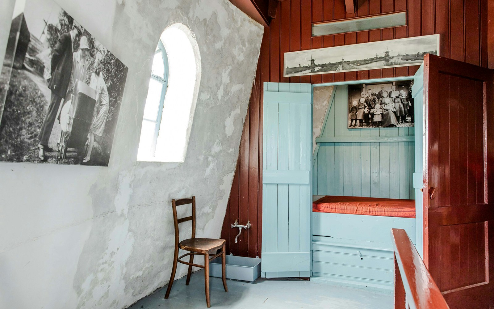 Interior of Nederwaard Museum Mill at Kinderdijk with historic photos and wooden furniture.