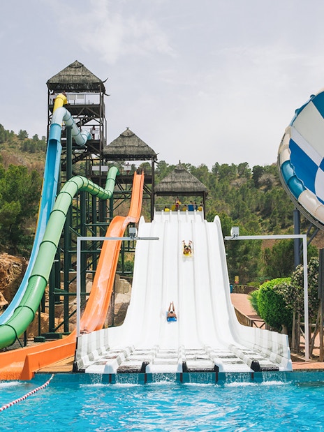 Water slides at Aqualandia Benidorm with riders descending into a pool.