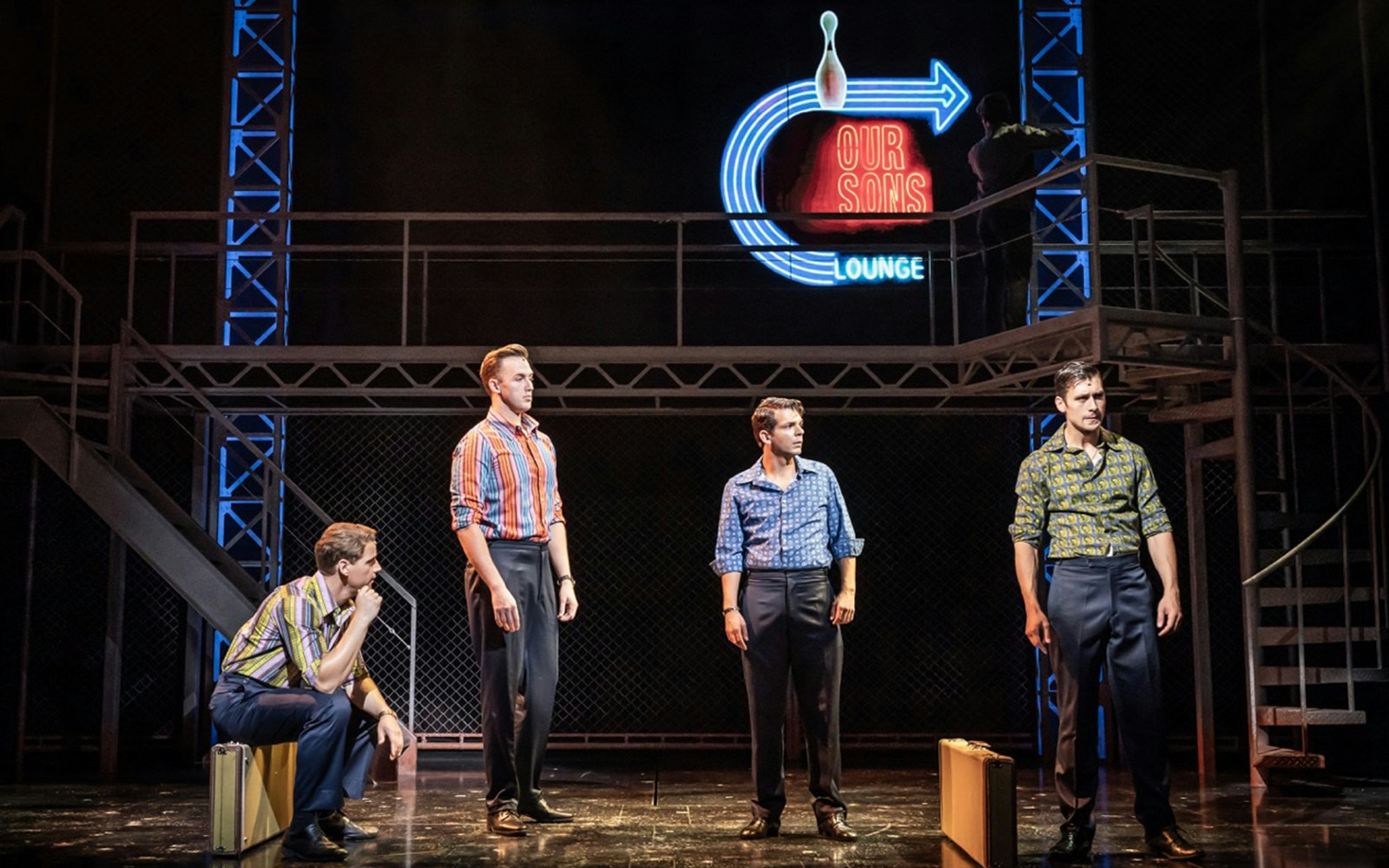 Four performers on stage in "Jersey Boys" musical scene.