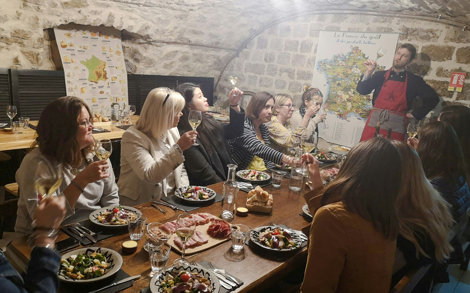 People enjoying a cheese and wine tasting at Paroles de Fromagers in Paris, France.