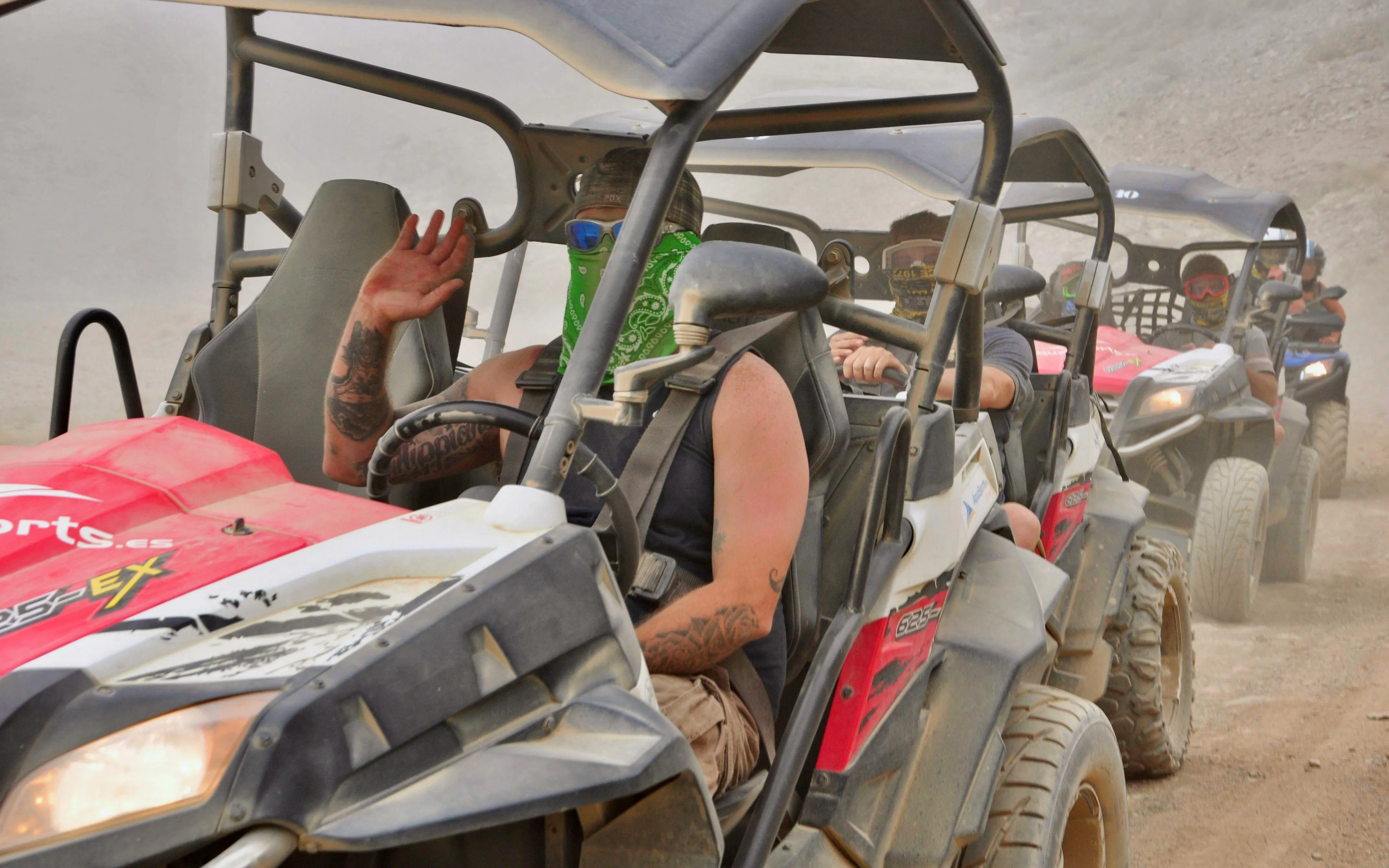 Buggy tour through dusty trails in Gran Canaria with drivers wearing bandanas.