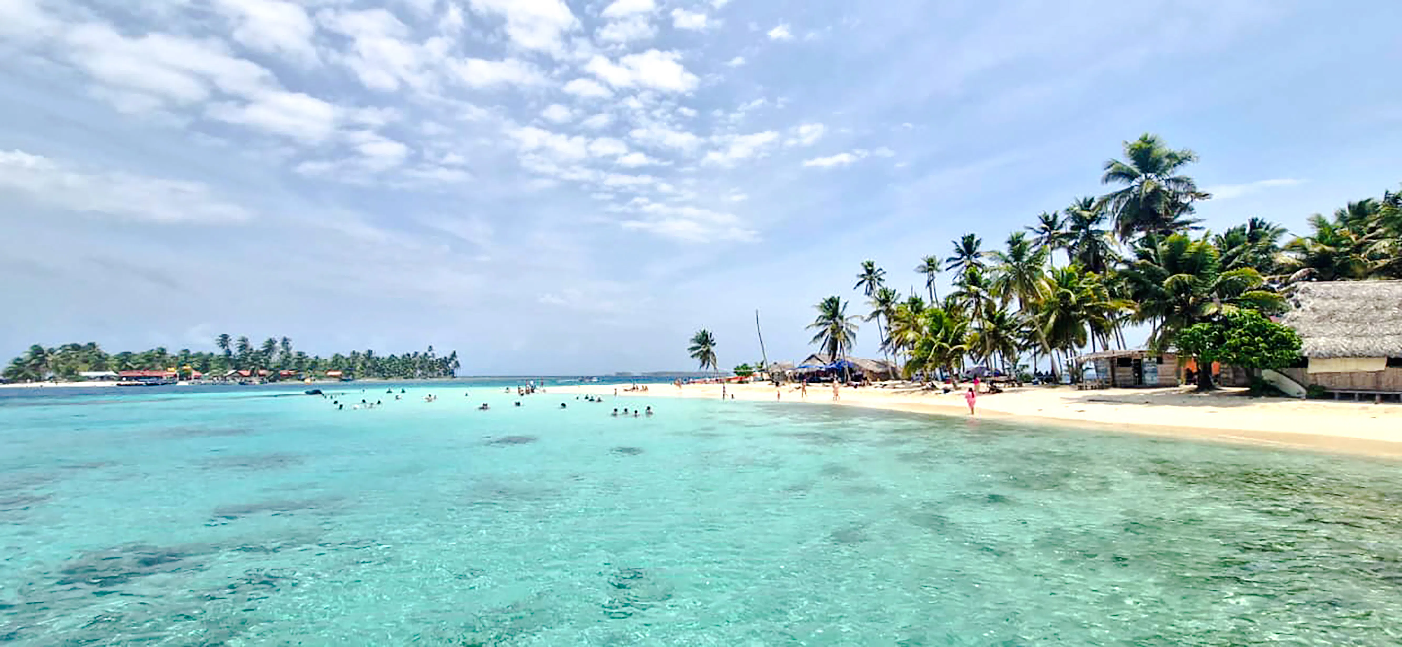 Beach with palm trees and clear water at Islas de San Blas, Panama City.