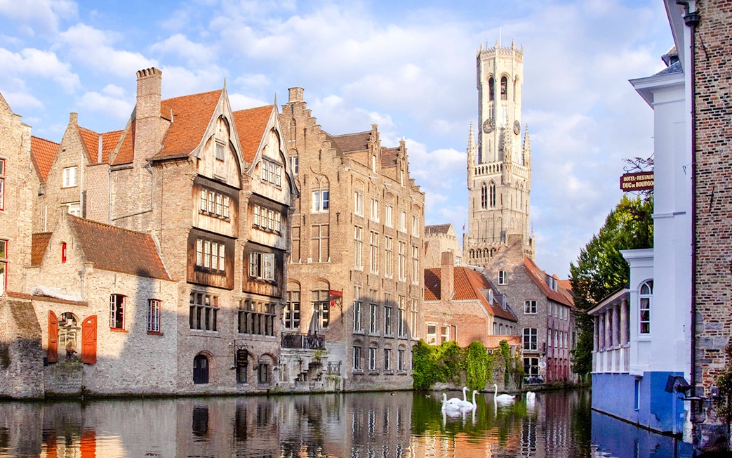 Historic buildings and Belfry of Bruges along Rozenhoedkaai canal in Bruges, Belgium.