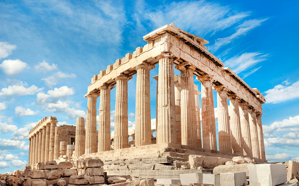 Parthenon temple on the Acropolis in Athens under a blue sky.