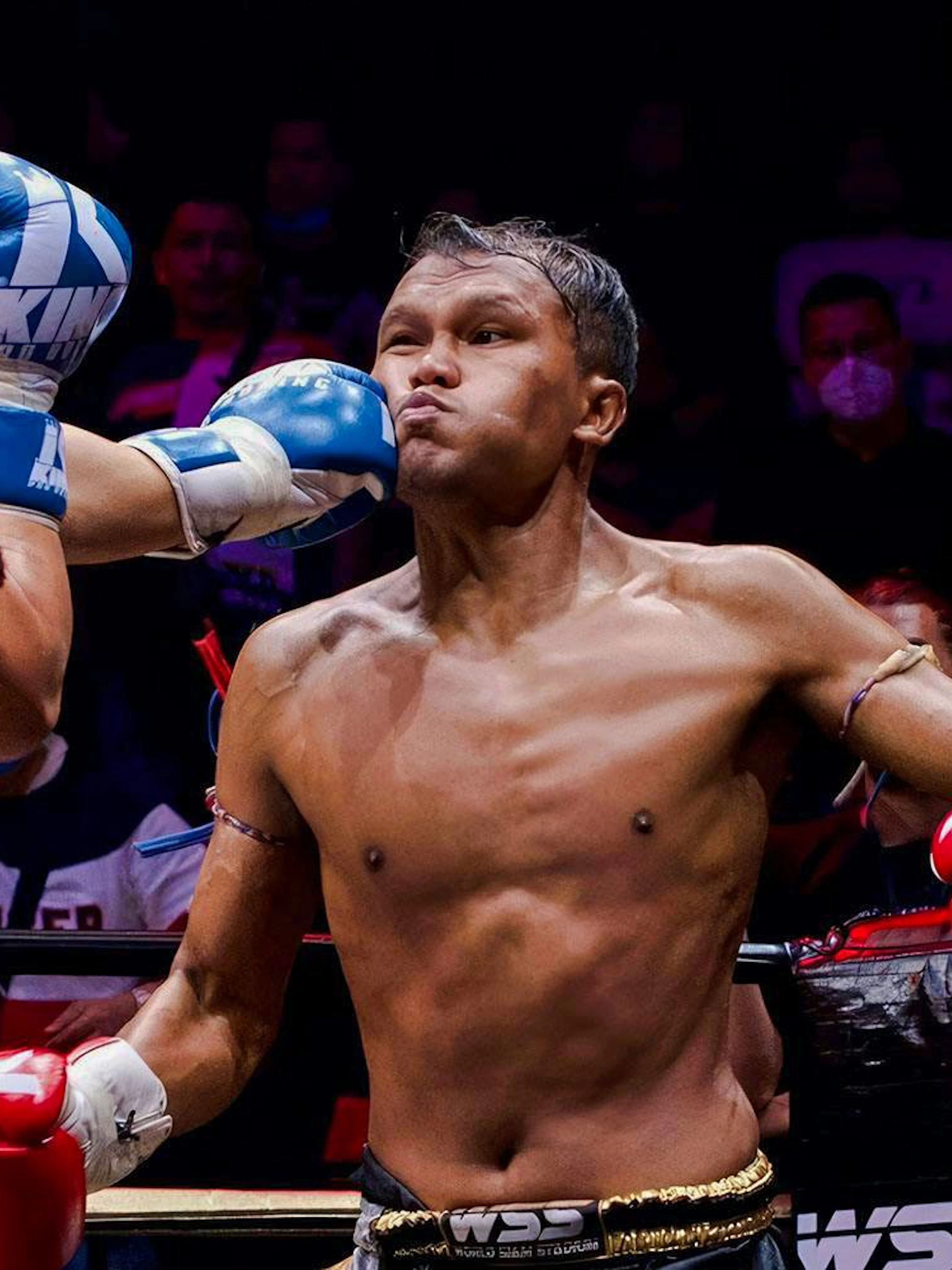 Fighter delivering a punch at SRC SIAM REAL COMBAT, World Siam Stadium, Bangkok.