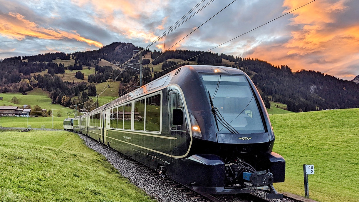 Golden Pass Express train traveling through scenic Swiss Alps landscape.