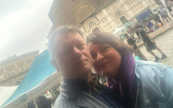 Couple in front of historic building during Bologna city exploration game.
