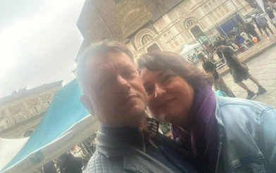 Couple in front of historic building during Bologna city exploration game.