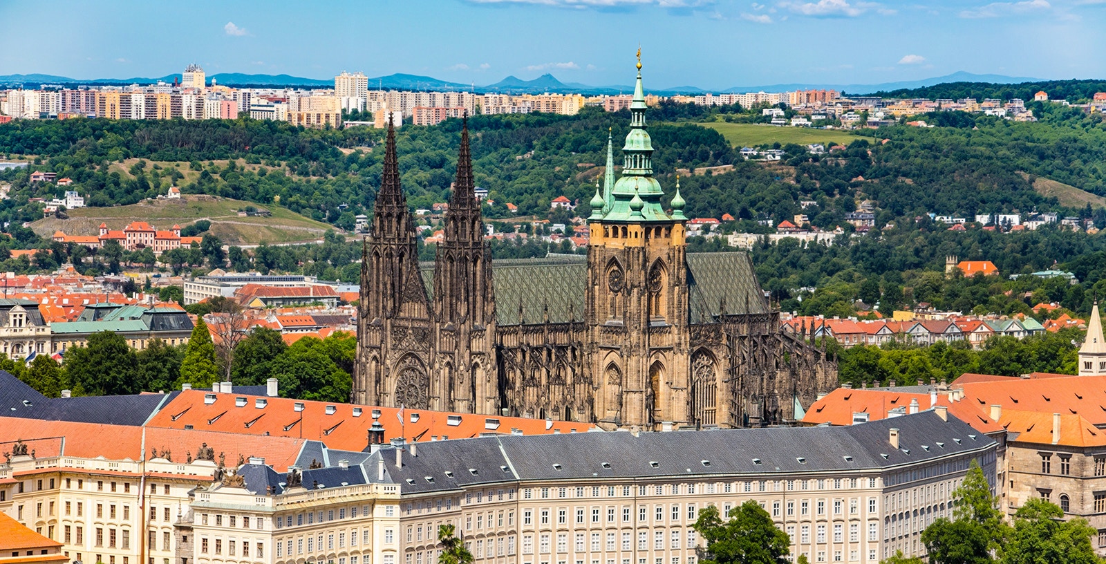Aerial view of Prague Castle with cityscape and greenery in Prague.