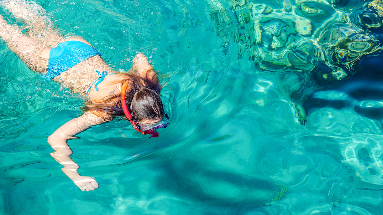 Teenage girl snorkeling in clear waters