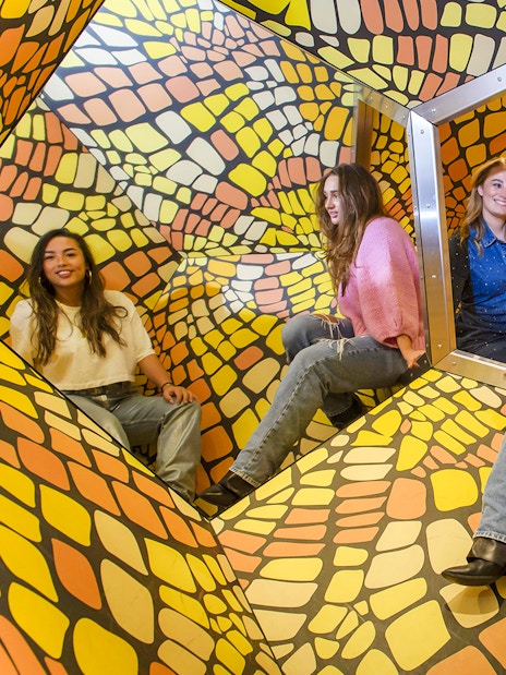 Group of people inside a colorful, geometric installation at The TUBE.