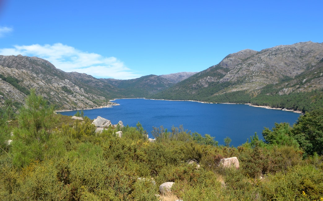 Peneda Gerês National Park lake view with surrounding mountains and greenery.