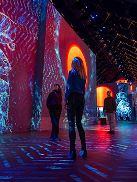 Visitors exploring immersive digital art projections at Fabrique des Lumières.