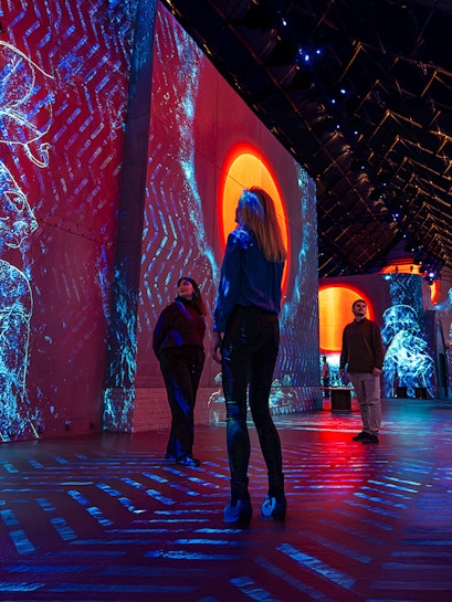 Visitors exploring immersive digital art projections at Fabrique des Lumières.