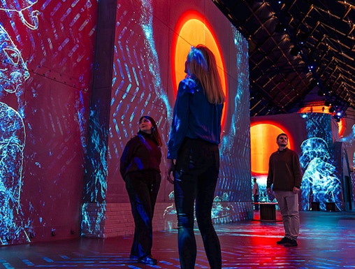 Visitors exploring immersive digital art projections at Fabrique des Lumières.