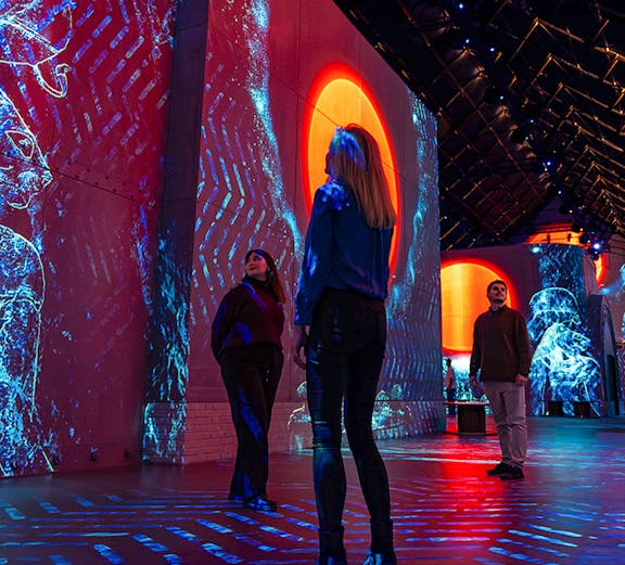 Visitors exploring immersive digital art projections at Fabrique des Lumières.