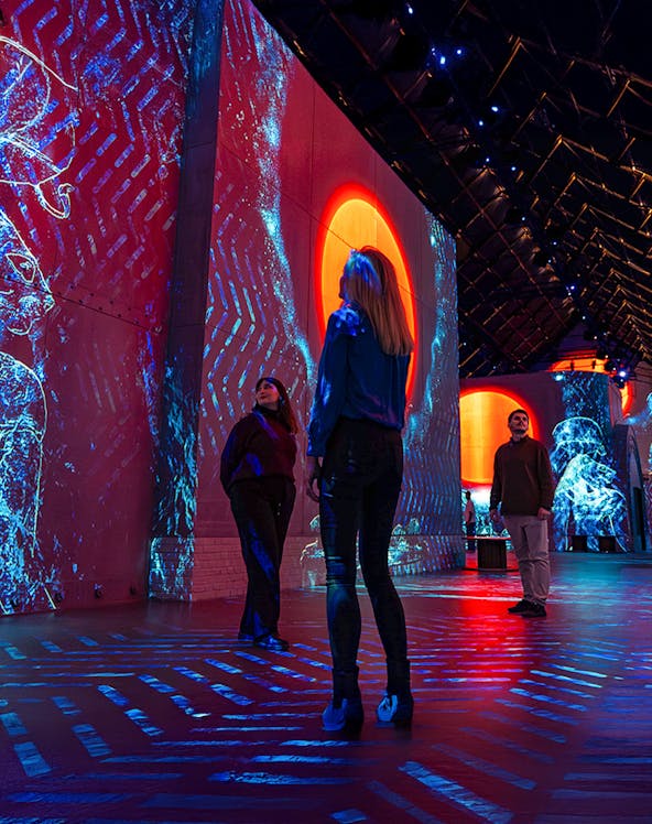 Visitors exploring immersive digital art projections at Fabrique des Lumières.