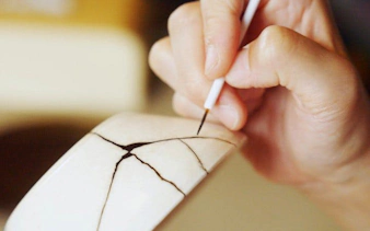 Kintsugi workshop participant repairing pottery with gold in Shinjuku, Tokyo.