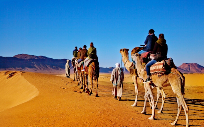 Camel caravan trekking through desert near Ait Ben-Haddou, Morocco.