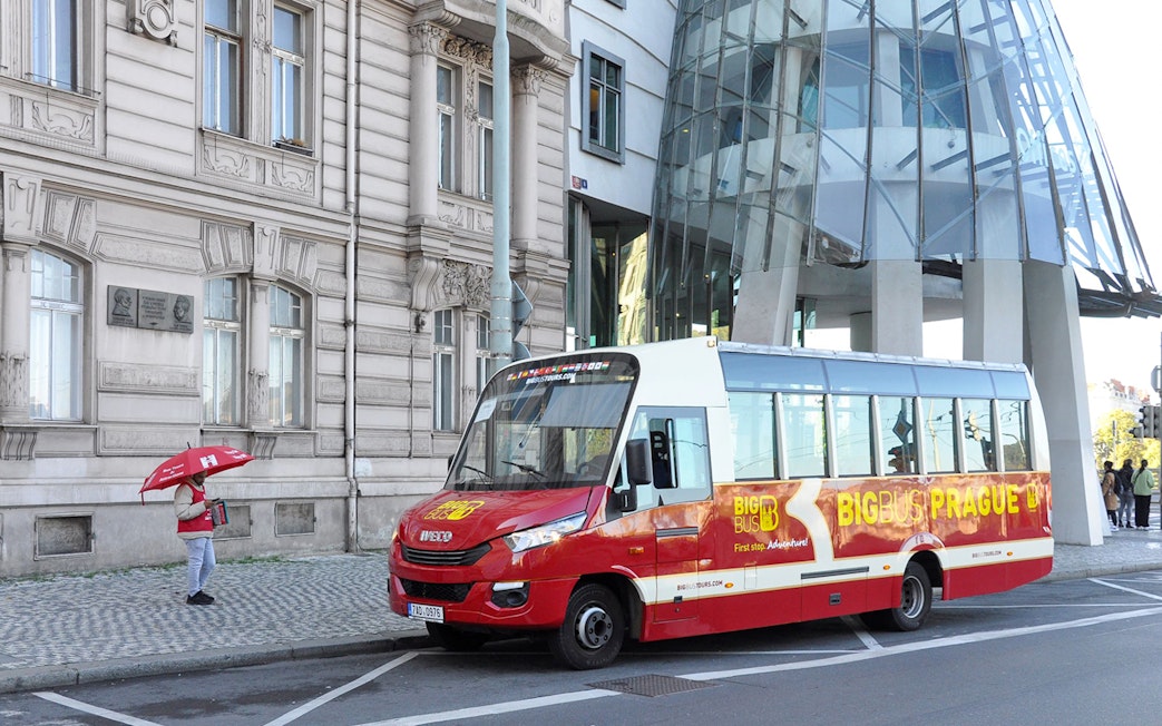 Hop-on hop-off tour bus in front of Prague's Dancing House.