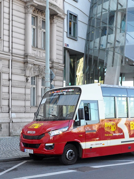 Hop-on hop-off tour bus in front of Prague's Dancing House.
