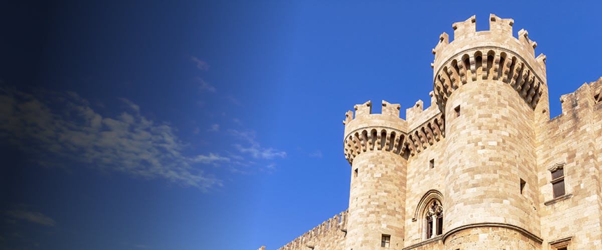 Medieval castle tower under blue sky in Rhodes, Greece.