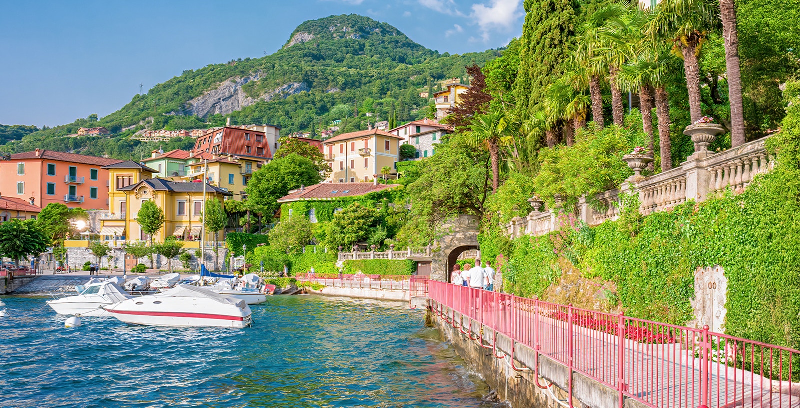 Milan to Lake Como tour boat cruising on scenic lake with mountain backdrop.