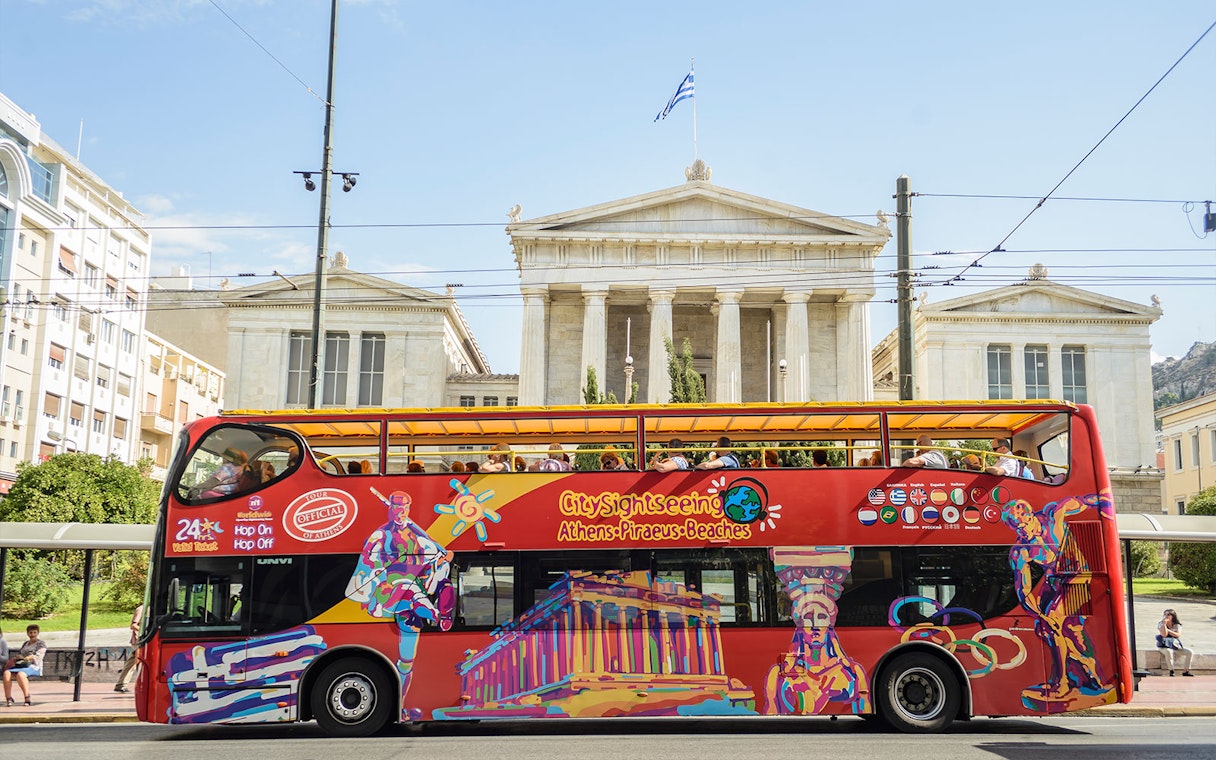 Open-top tour bus in front of the Vallianeio Megaron, Athens.