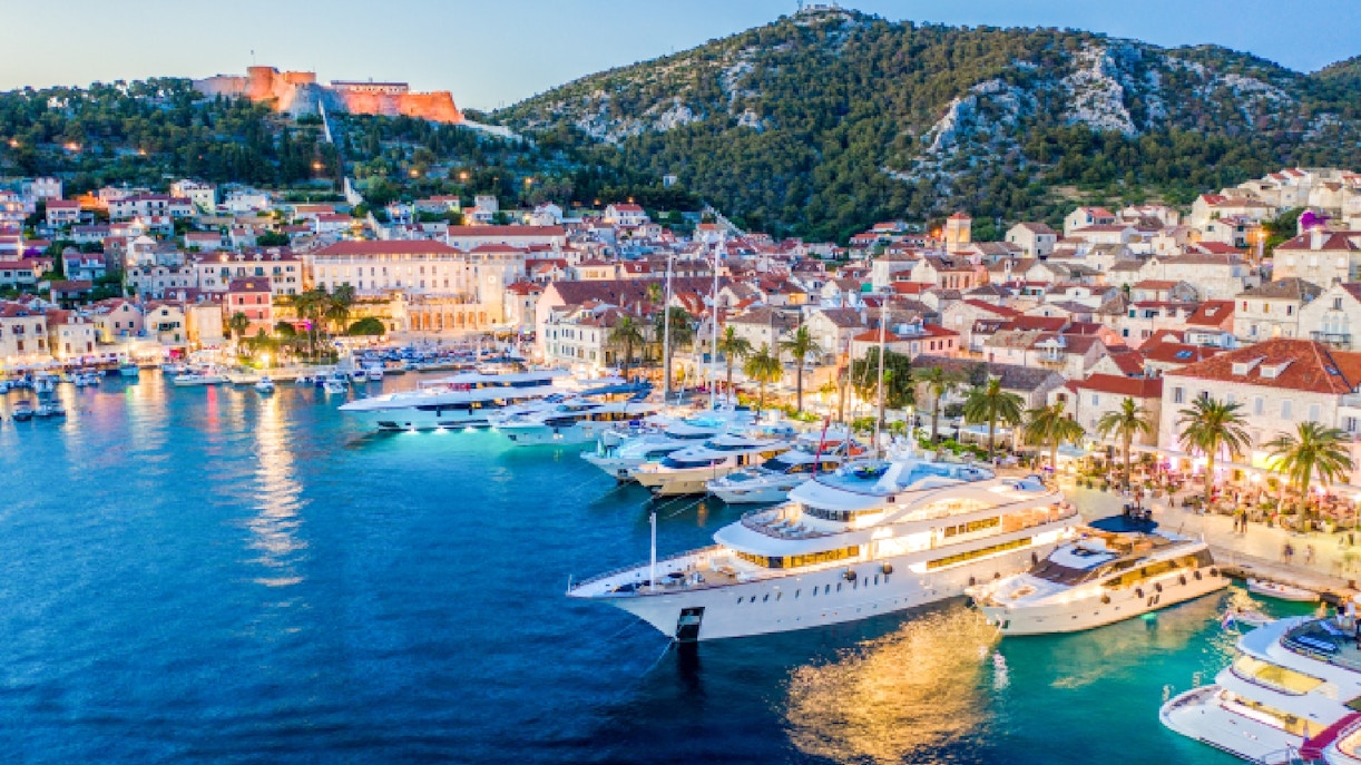 Yachts docked along the coast of Hvar, Croatia with historic buildings in the background.