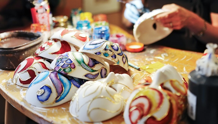 Venetian artisan crafting traditional mask in costume workshop, Venice, Italy.
