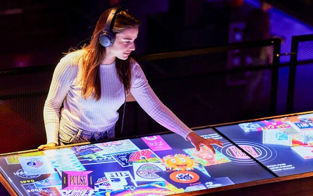 Visitor interacting with digital display at Our House Museum of Electronic Dance Music.