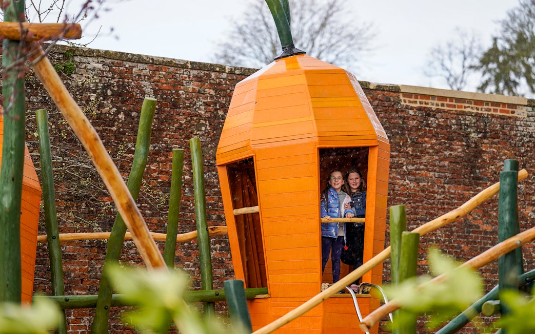 Children playing in a wooden structure at Blenheim Palace Adventure Play.