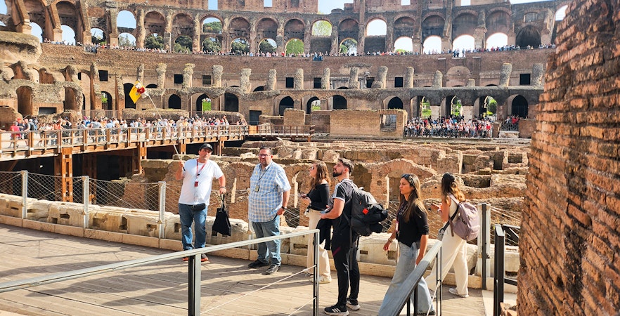 Visitors exploring the interior of the Colosseum on a private guided tour in Rome.