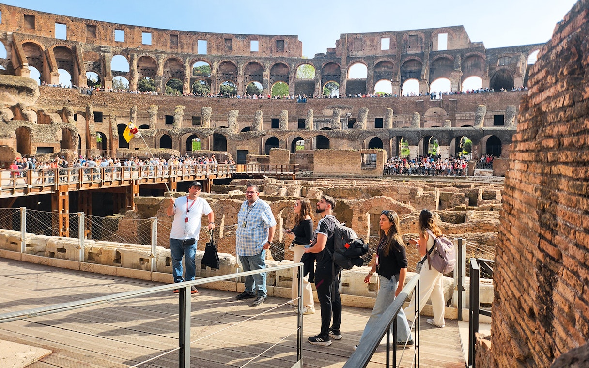Visitors exploring the interior of the Colosseum on a private guided tour in Rome.