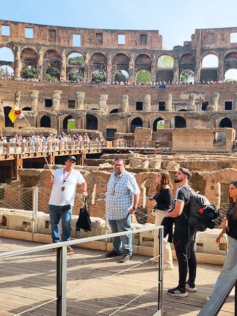 Visitors exploring the interior of the Colosseum on a private guided tour in Rome.