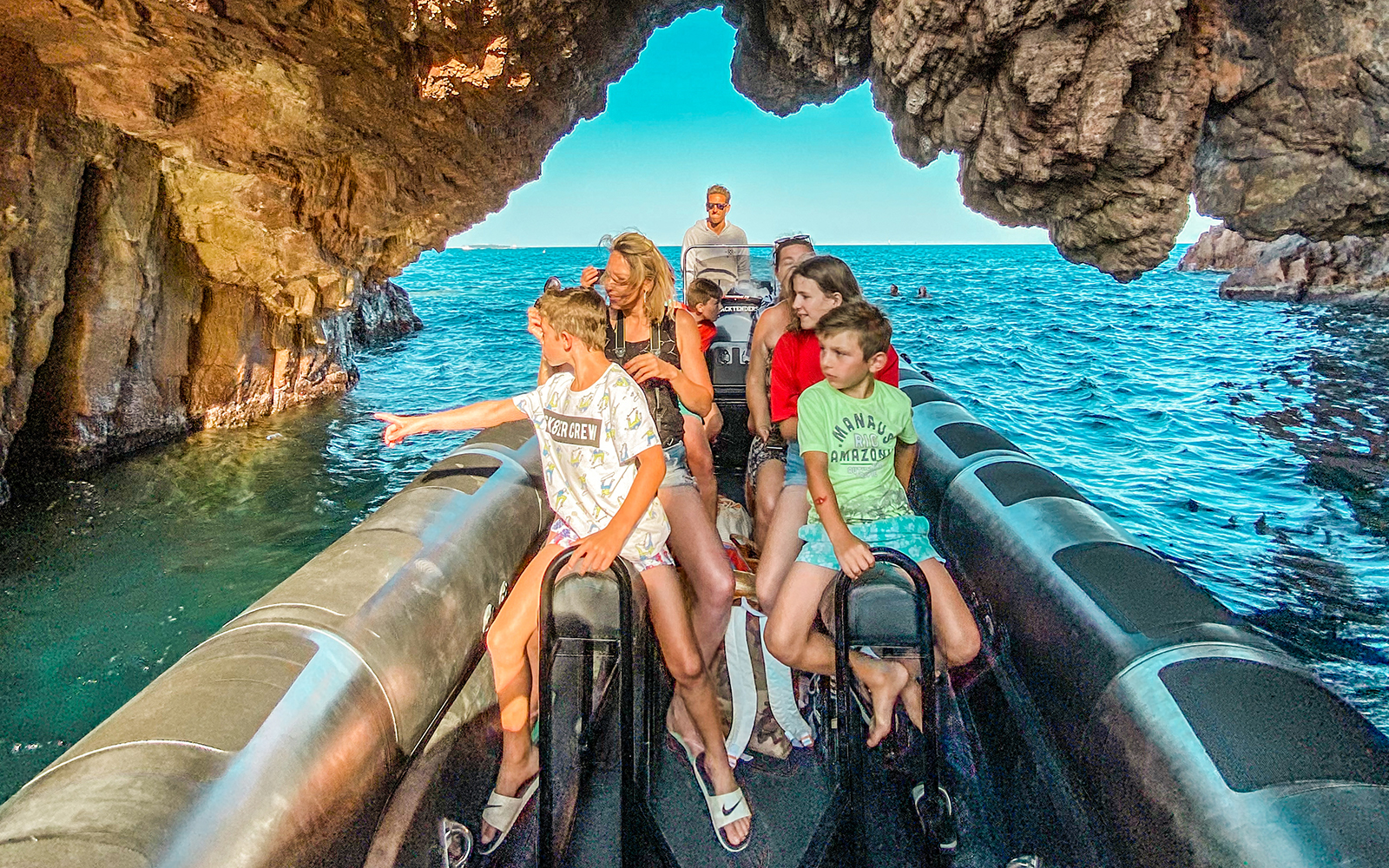 Family on boat tour exploring Esterel National Park's hidden coves.